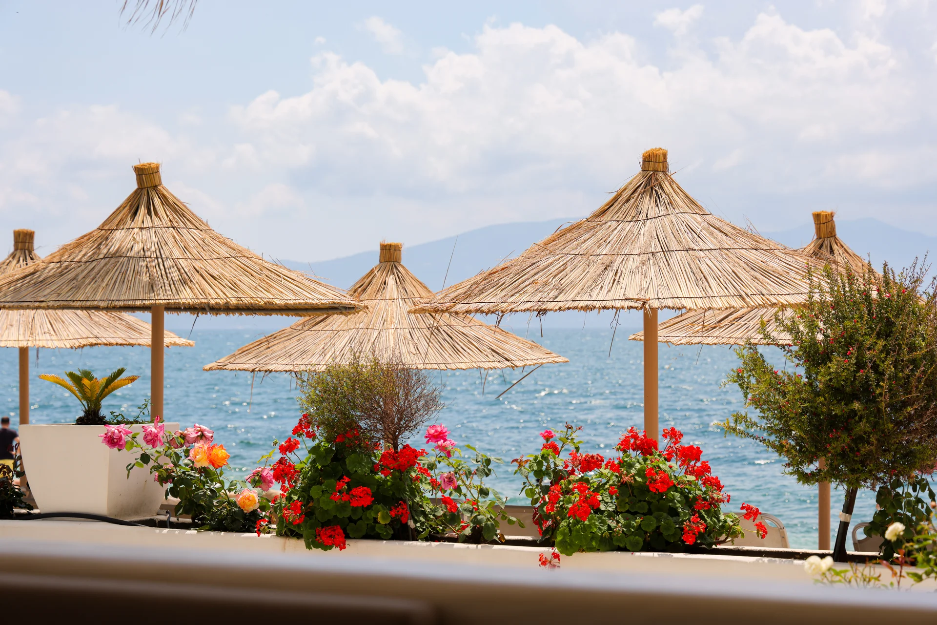 Saranda International Beach — straw umbrellas and Ionian Sea
